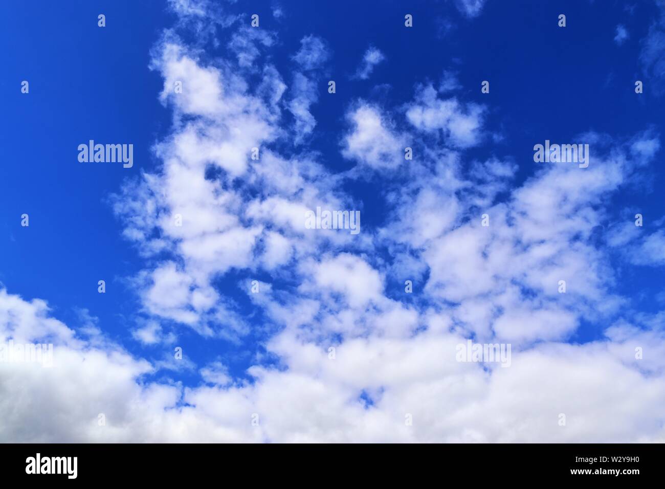 Entspannende Aussicht auf flauschigen weissen Wolken an einem tiefblauen Himmel Stockfoto