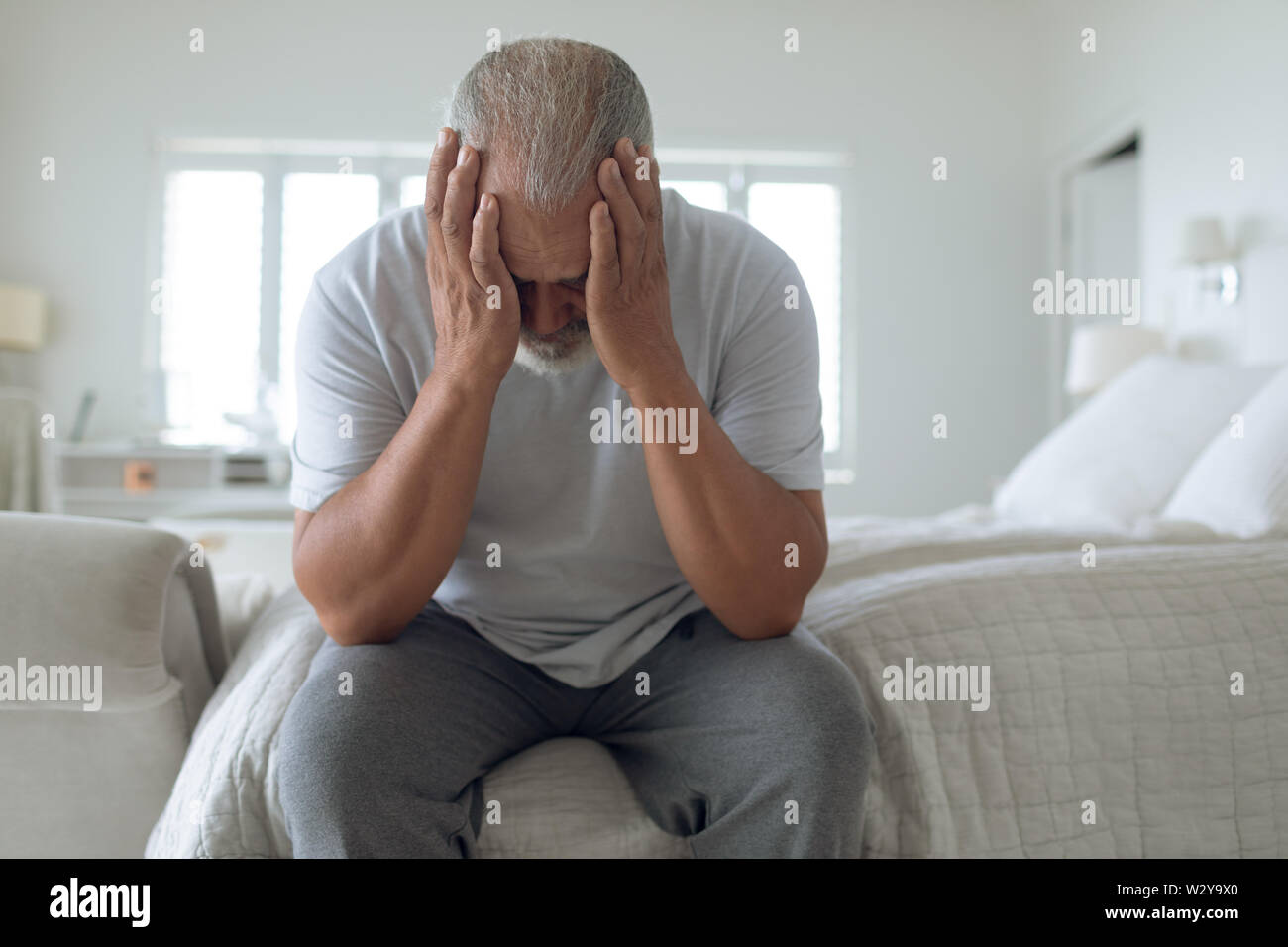 Mann sitzt auf dem Bett Stockfoto