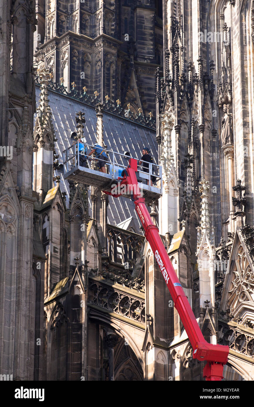 Arbeiter auf einer Hubarbeitsbühne an der Nordseite der Kathedrale, Köln, Deutschland. Arbeiter in einer LKW-Arbeitsbuehne an der Nordseite des Do Stockfoto