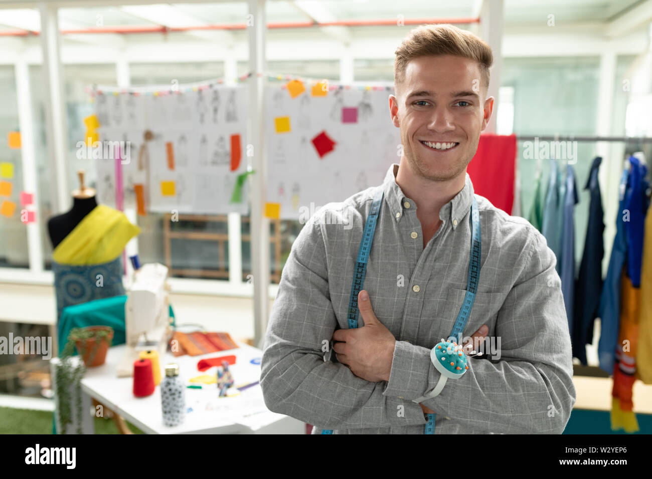 Männliche Fashion Designer stehend mit Waffen in Design Studio gekreuzt Stockfoto