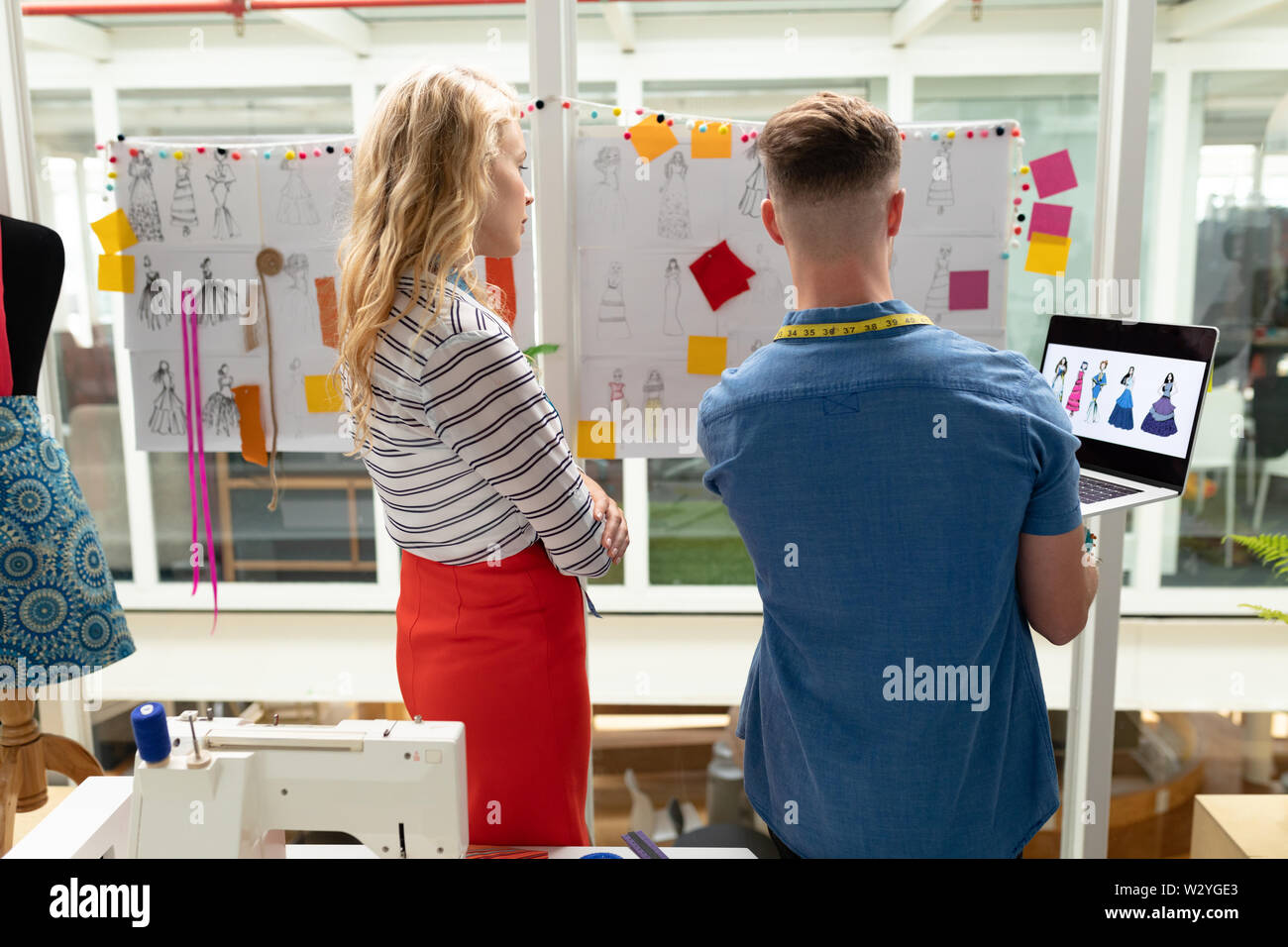 Männliche und Modedesigner diskutieren über Skizze in Design Studio Stockfoto