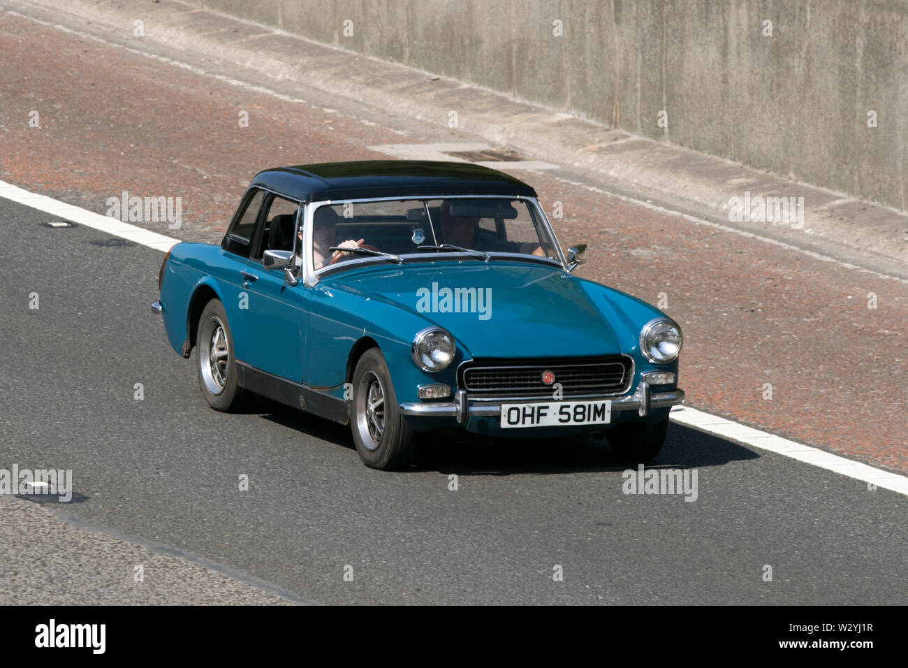 1972 Blau MG Midget; Vintage classic restaurierte Fahrzeuge Autos auf der Autobahn M6 an der Leighton Hall Car Show in Carnforth, Lancaster, Großbritannien reisen Stockfoto