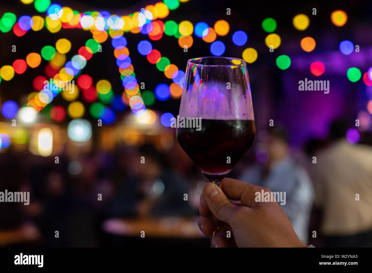 Festival Sommer Event mit Licht bokeh und ein Glas Rotwein Wein Festival mit bunten Lichtern Stockfoto