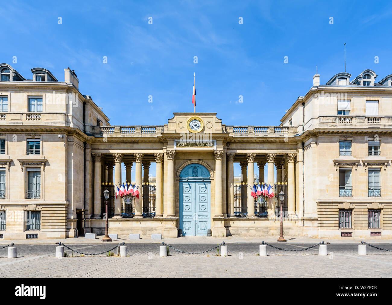 Vorderansicht des südlichen Eingang des Palais Bourbon, Sitz der Französischen Nationalversammlung in Paris, Frankreich, mit französischen Fahnen geschmückt. Stockfoto