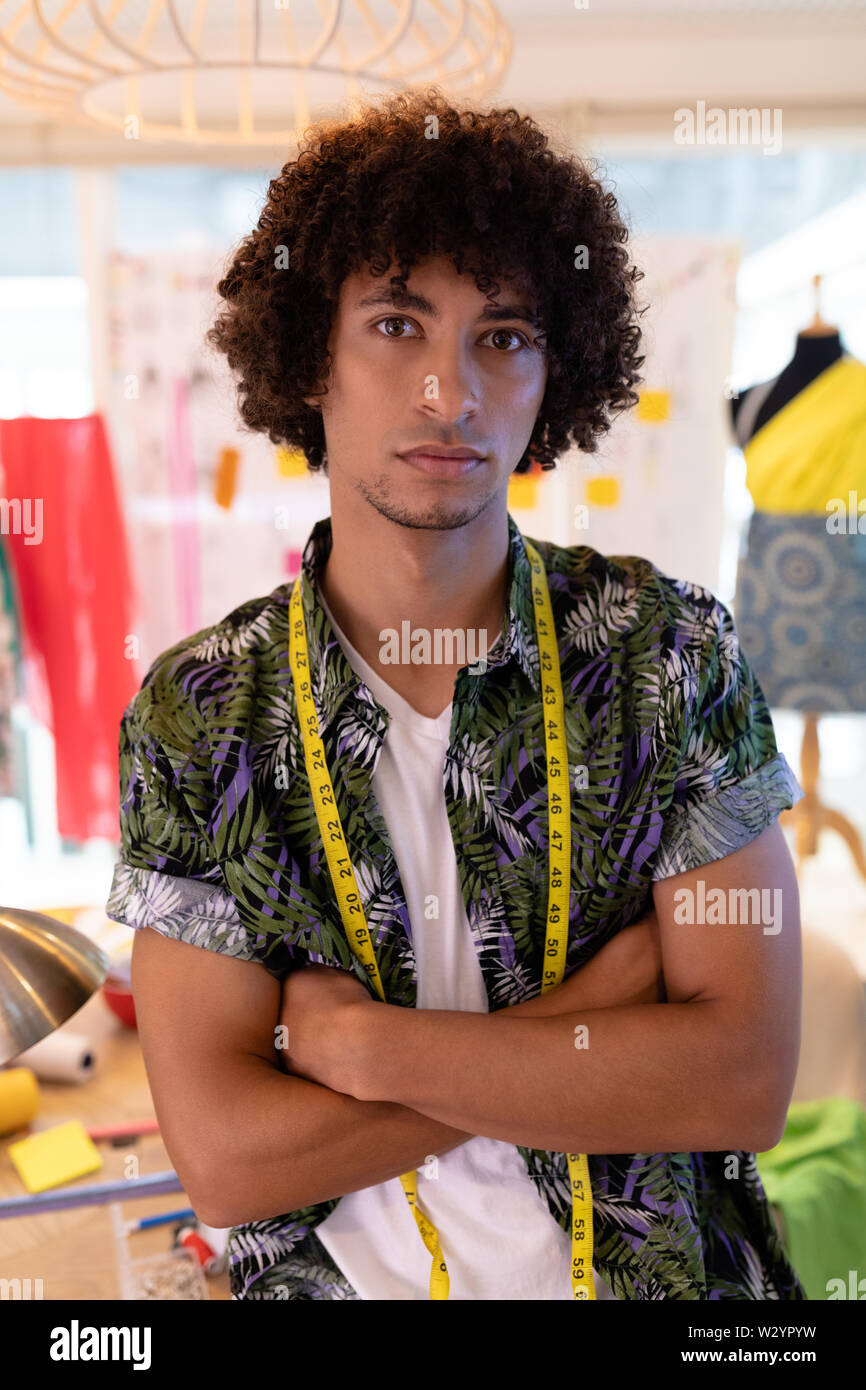 Männliche Fashion Designer Sitzen mit gekreuzten Armen im Design Studio Stockfoto