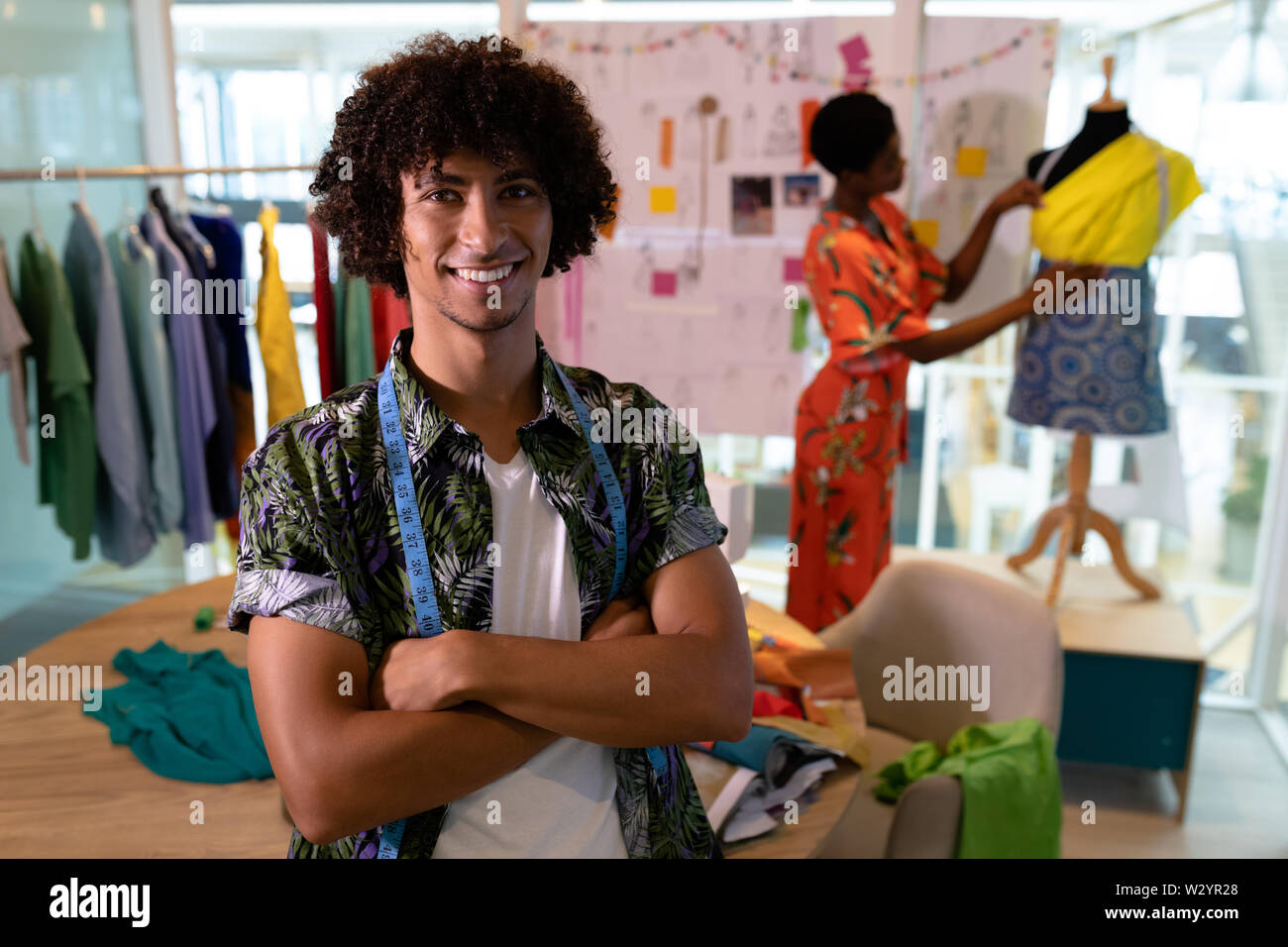 Männliche Fashion Designer Sitzen mit gekreuzten Armen im Design Studio Stockfoto
