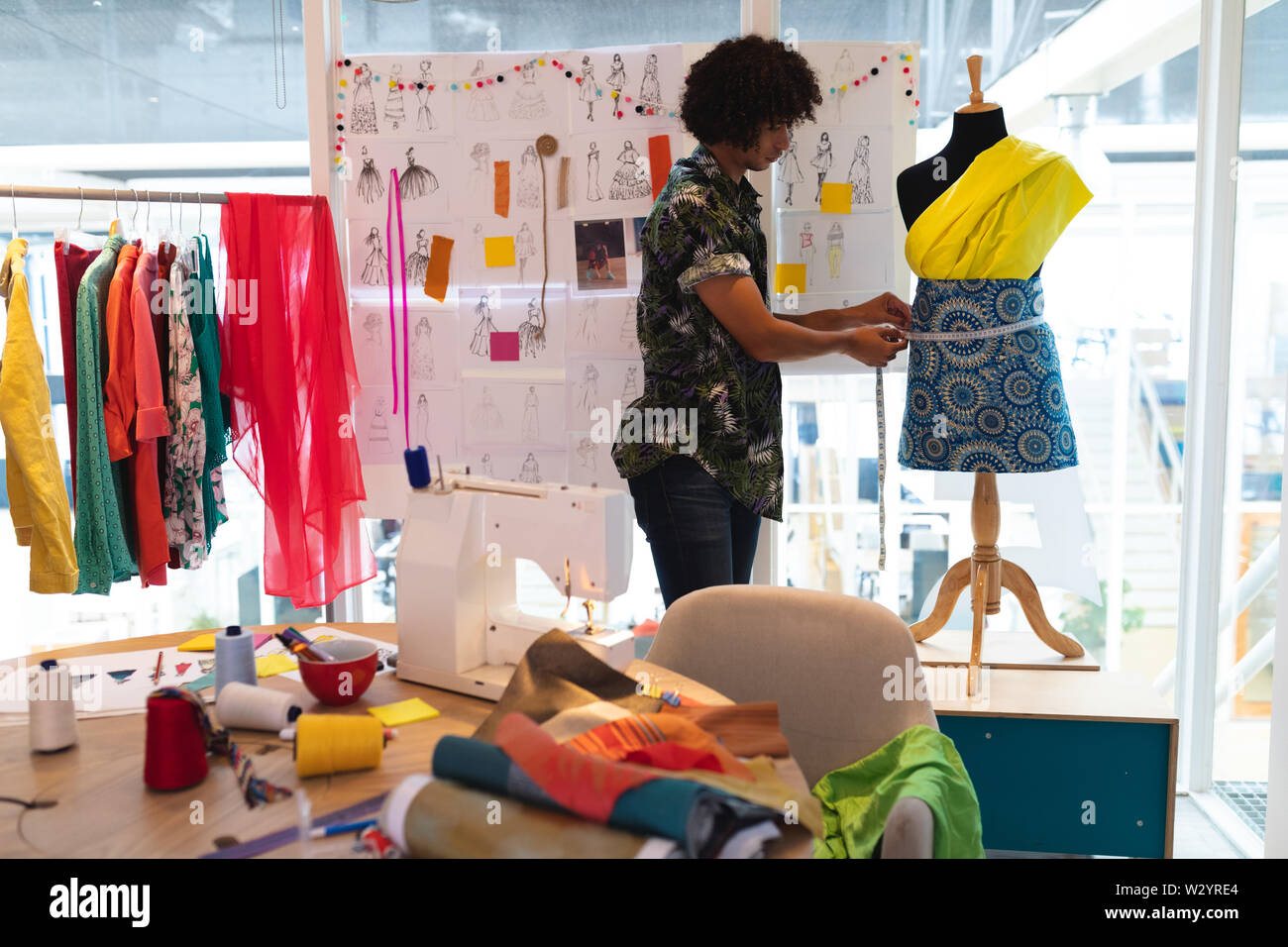 Männliche Modedesigner mit Maßband auf ein Mannequin Stockfoto