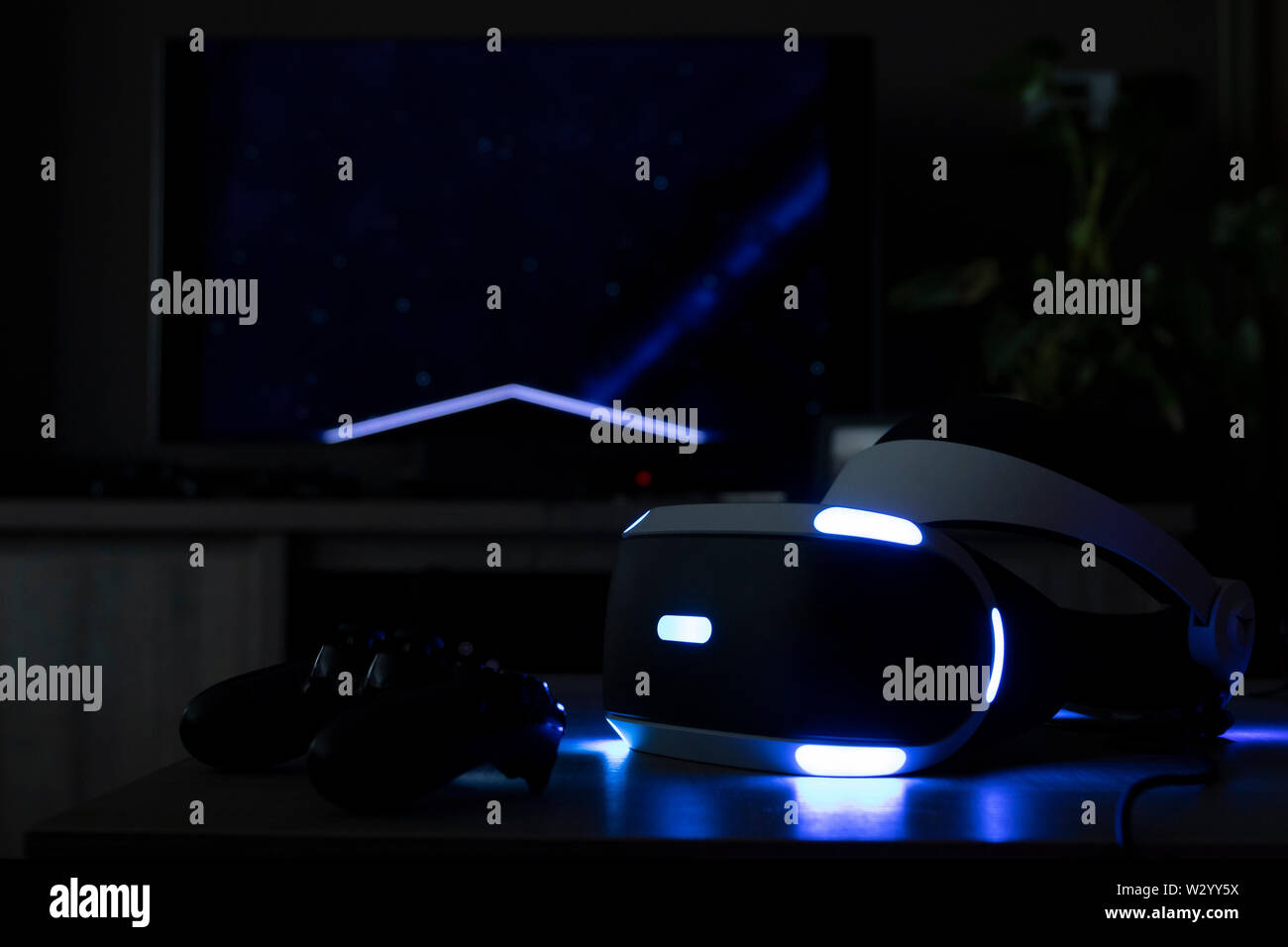 Brecht, Belgien - 12. Juni 2019: eine Playstation VR-Headset in einem dunklen Raum mit seinem Wahrzeichen Lichter vor einem Fernseher und Playstation 4 kontro Stockfoto