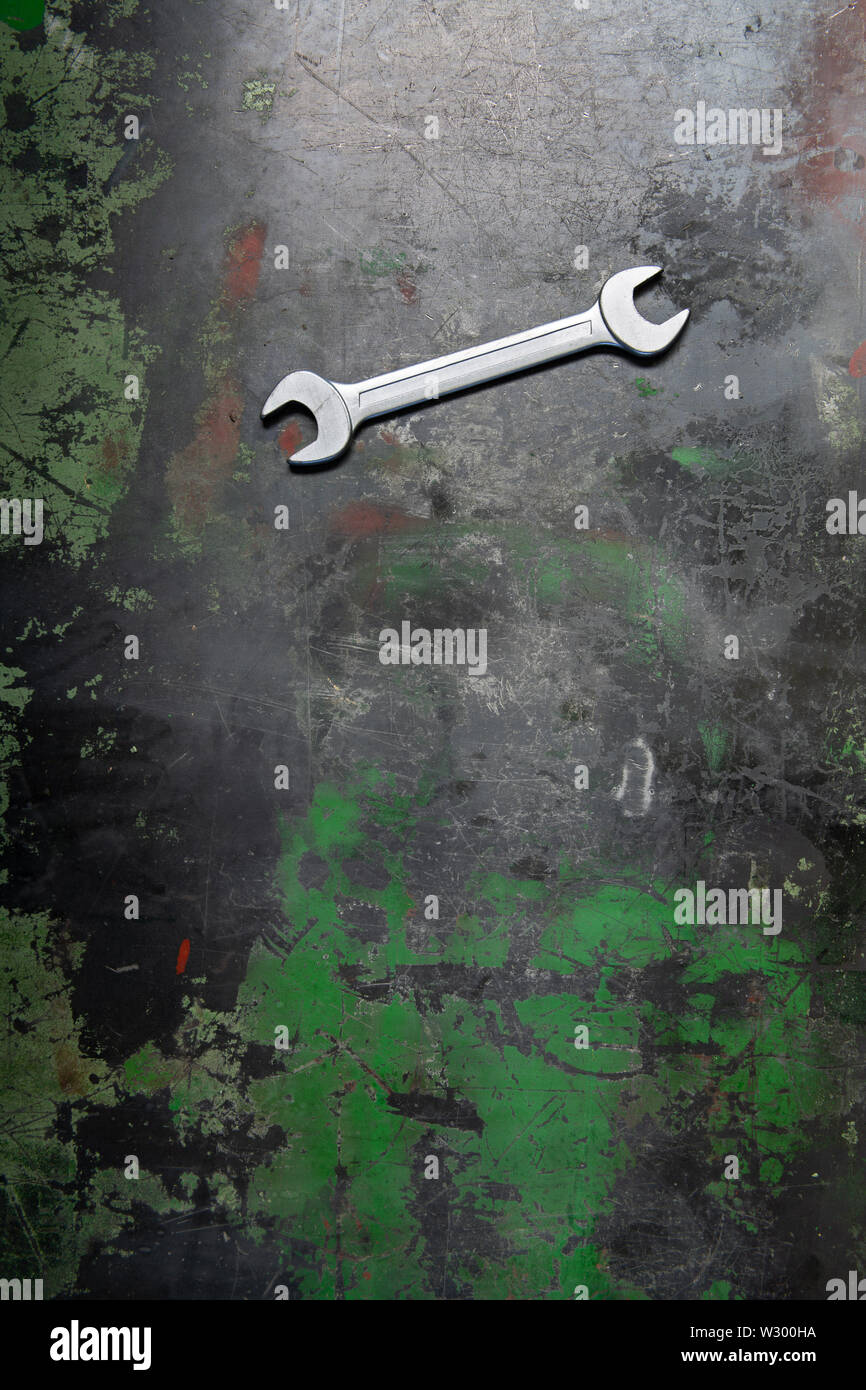 Ein Schlüssel liegt auf einem Metall Werkbank mit Spuren von Arbeit und geschliffen Farbe. Stockfoto
