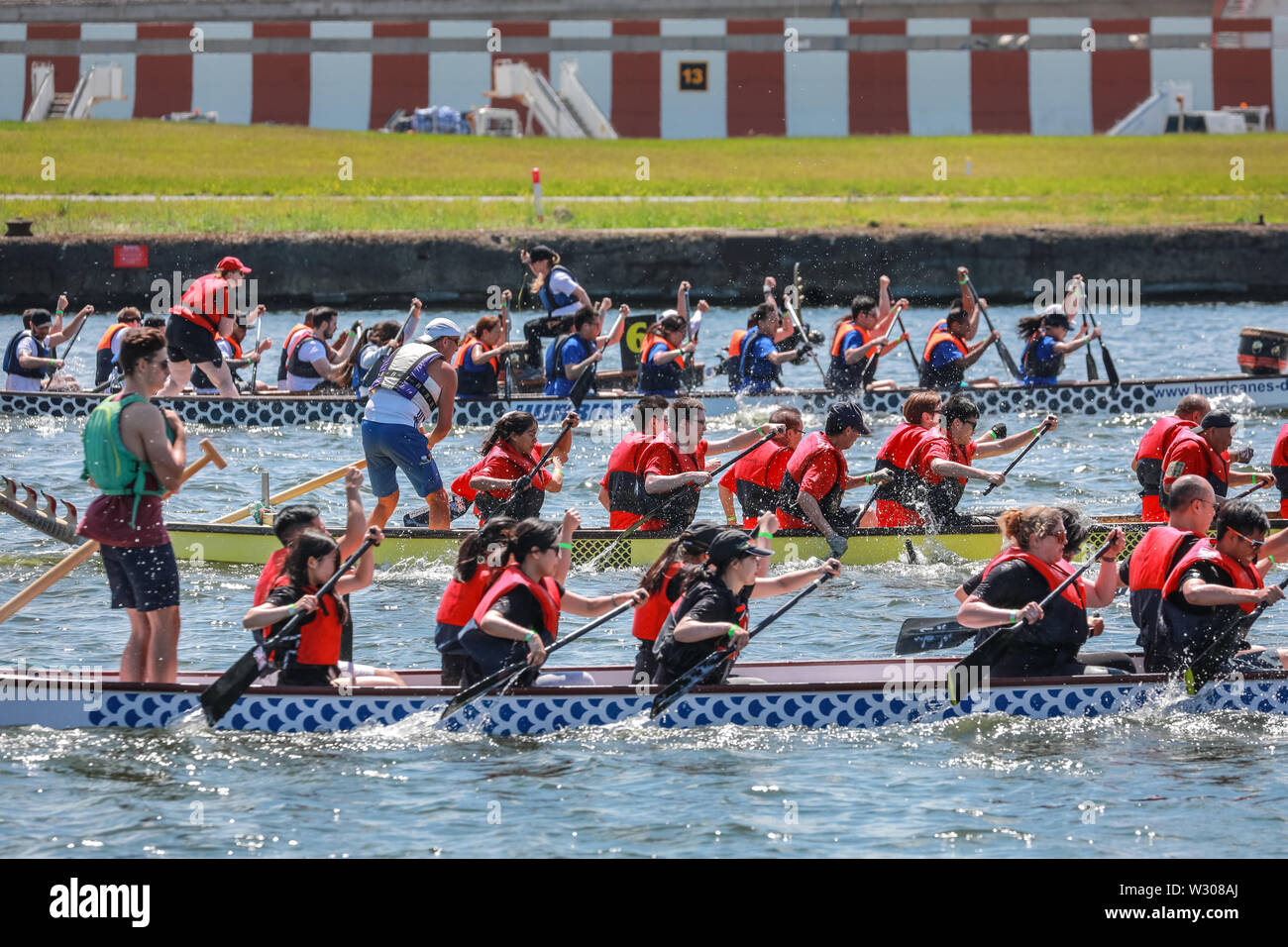 Dragon Boat racing teams gegeneinander in London Hong Kong Dragon Boat Festival im schönen Sonnenschein, Royal Docks in London, Großbritannien Stockfoto