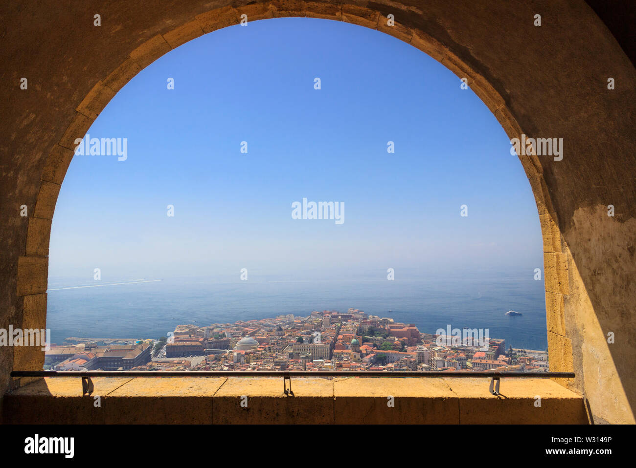 Panoramablick über die Stadt Neapel durch den Bogen der mittelalterlichen Festung Castel Sant'Elmo. Skyline und den Golf von Neapel, Kampanien, Italien. Stockfoto