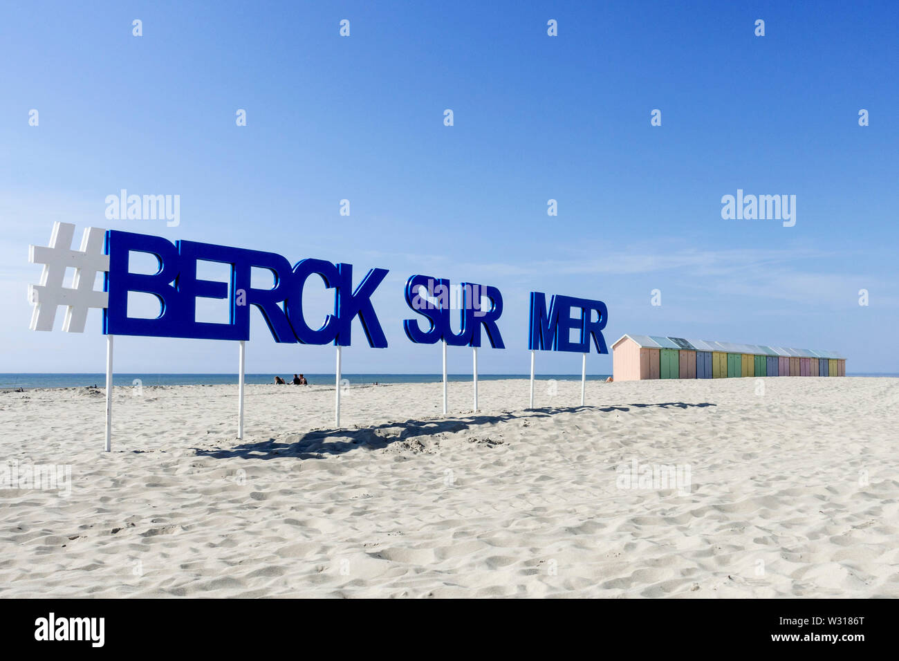 Schild mit großen Buchstaben und pastellfarbenen Beach Cabins im Seaside Resort Berck-sur-Mer entlang der Nordseeküste, Côte d'Opale/Opal Küste, Frankreich Stockfoto