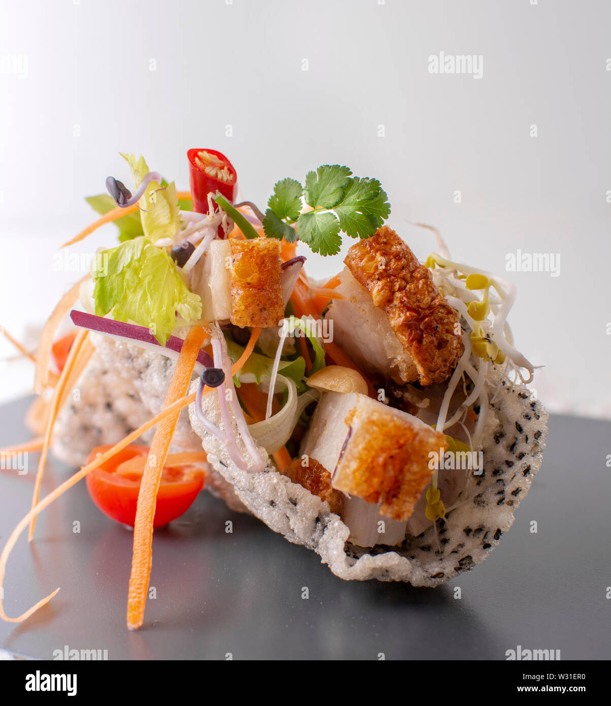 Asiatische seald Schalen und Teller aus einer thailändischen Glas Nudelsalat, einem thailändischen Geröstete knuspriges Schweinefleisch Salat und einem vietnamesischen Mango und pomelo Salat mit Fr Stockfoto