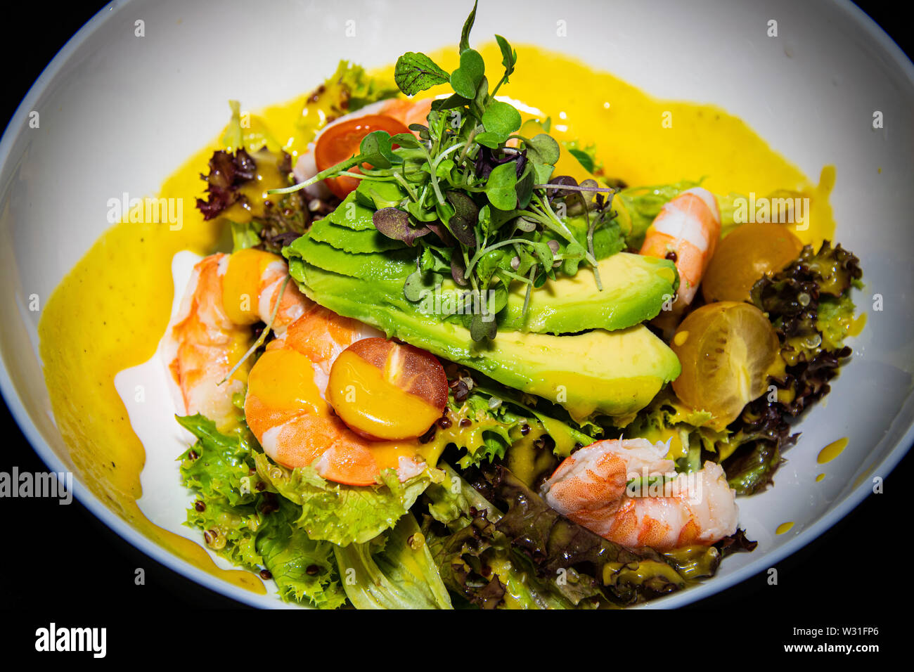 Eine Nahaufnahme eine Garnele und Avocado gemischter Blattsalat mit Zitrone und Kräuter Dressing Stockfoto