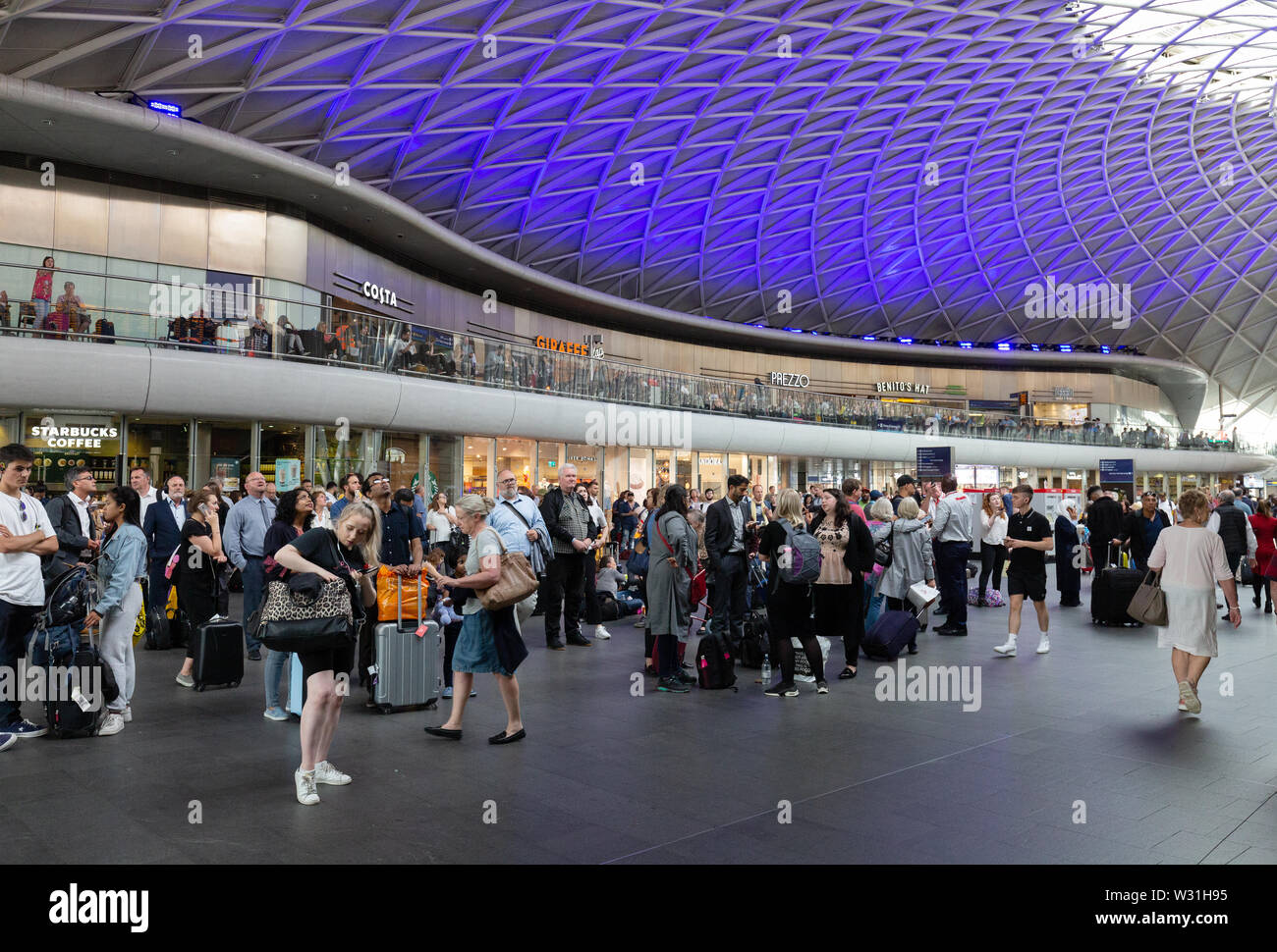 Kings Cross Bahnhofshalle mit Geschäften und Passagiere, Kings Cross Station London Großbritannien Stockfoto