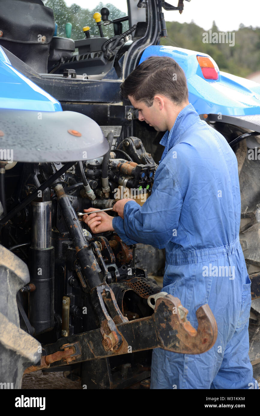 Greymouth, Neuseeland; Dezember 15, 2018: Ein namenloser Mechaniker arbeitet an der Rückseite des Traktors. Stockfoto