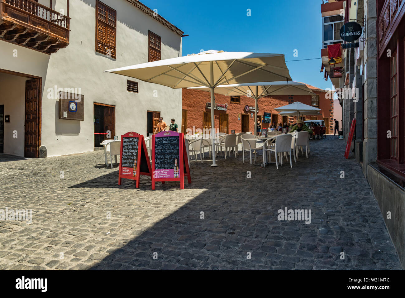 Puerto de la Cruz, Teneriffa, Spanien - Juli 10, 2019: Bunte Häuser und Palmen auf Straßen. Menschen entspannen und Spaß an einem warmen Sommertag. Stockfoto