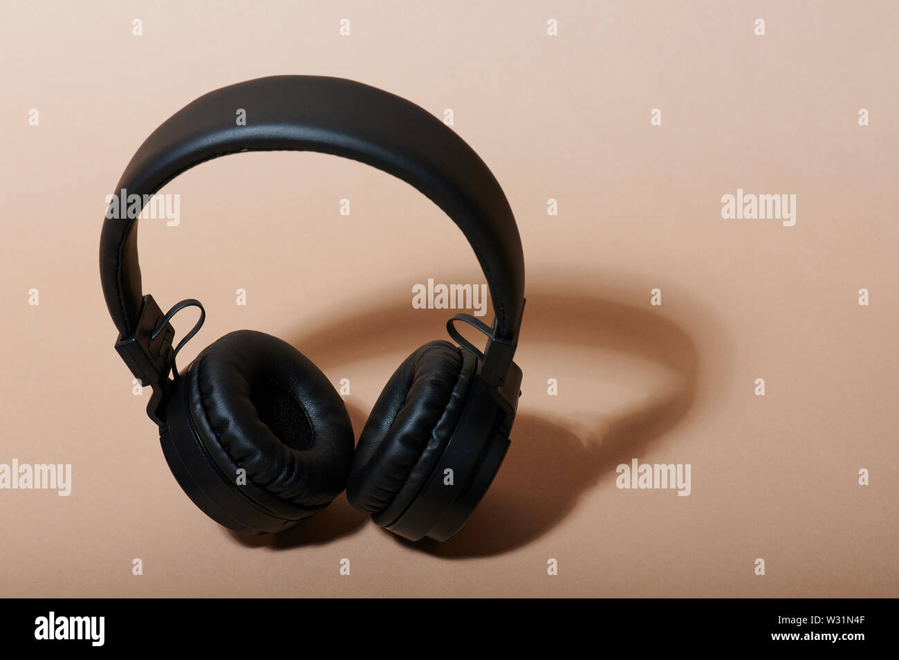 Schwarz Kopfhörer isometrische Ansicht auf beige Farbe Hintergrund Stockfoto