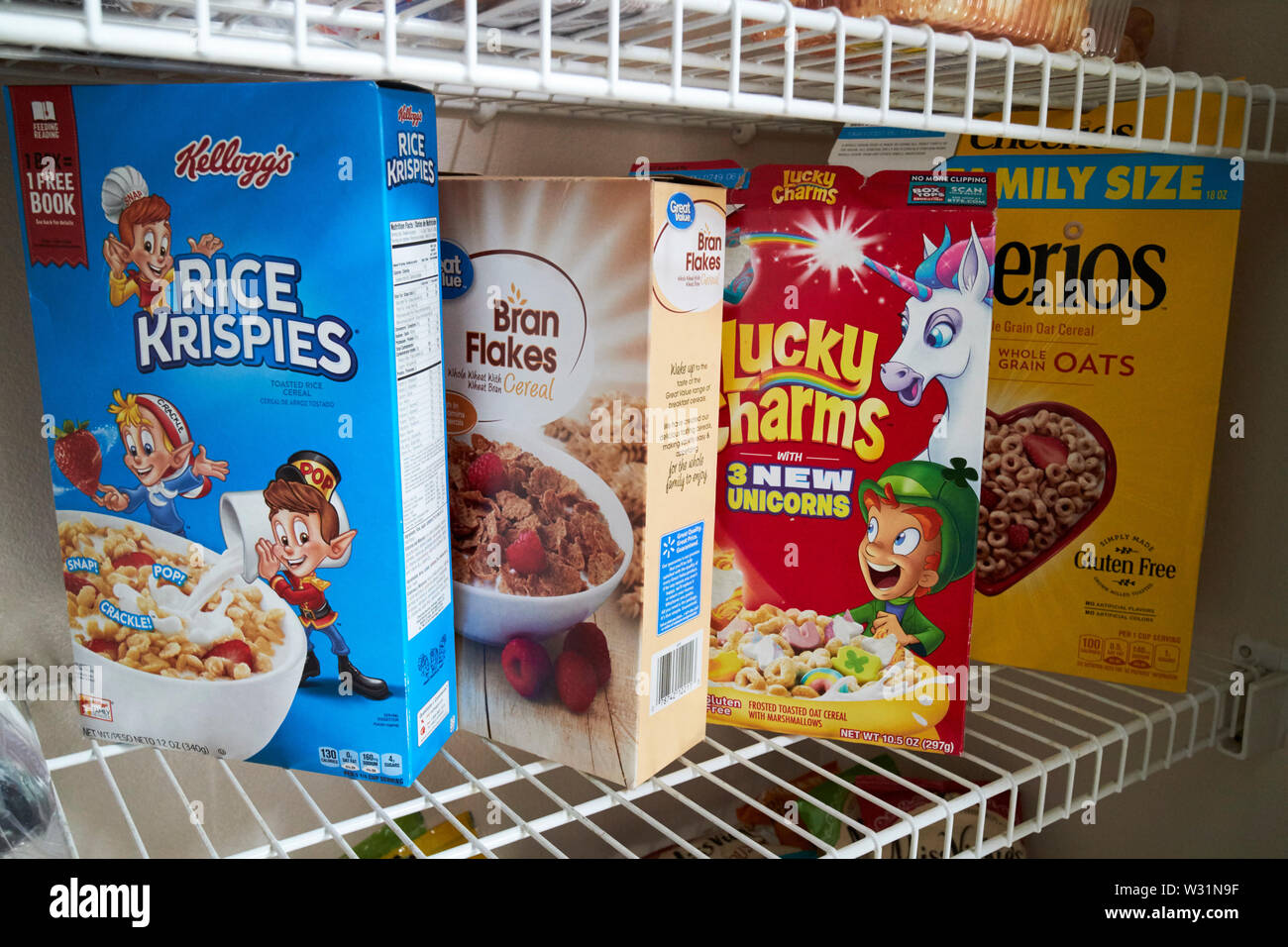 Verschiedene Getreide einschließlich Reis krispies Kleie flocken Glücksbringer und Cheerios Cerealien in einem Schrank in den USA Vereinigte Staaten von Amerika Stockfoto