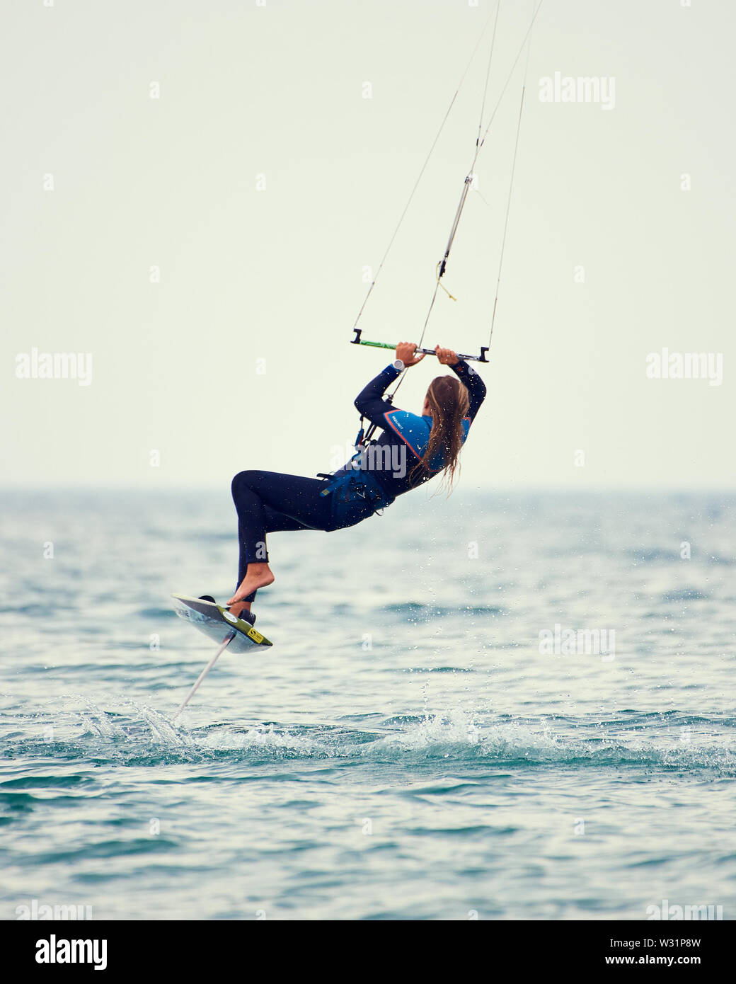 Armada Kiteboarding Festival. Frau hob vom Wasser in der Luft drehen. Ein Fuß vom Board. Stockfoto