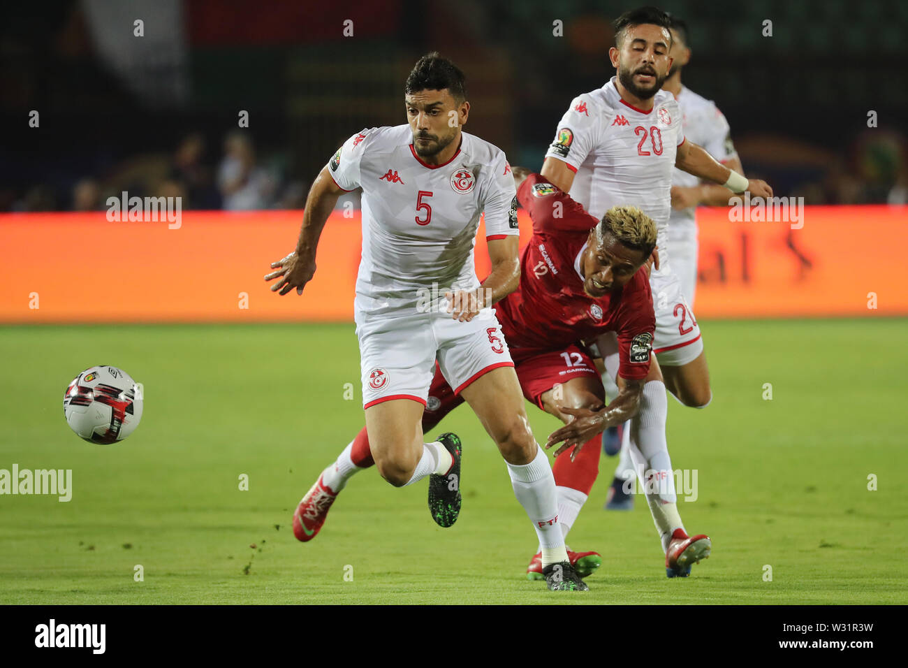 11 Juli 2019, Ägypten, Kairo: Madagaskar's Lalaina Nomenjanahary (C) und in Tunesien Oussama Haddadi (L) kämpfen um den Ball während der 2019 Afrika Cup von Quartal Nationen letzte Fußballspiel zwischen Madagaskar und Tunesien Al-Salam Stadion. Foto: gehad Hamdy/dpa Stockfoto