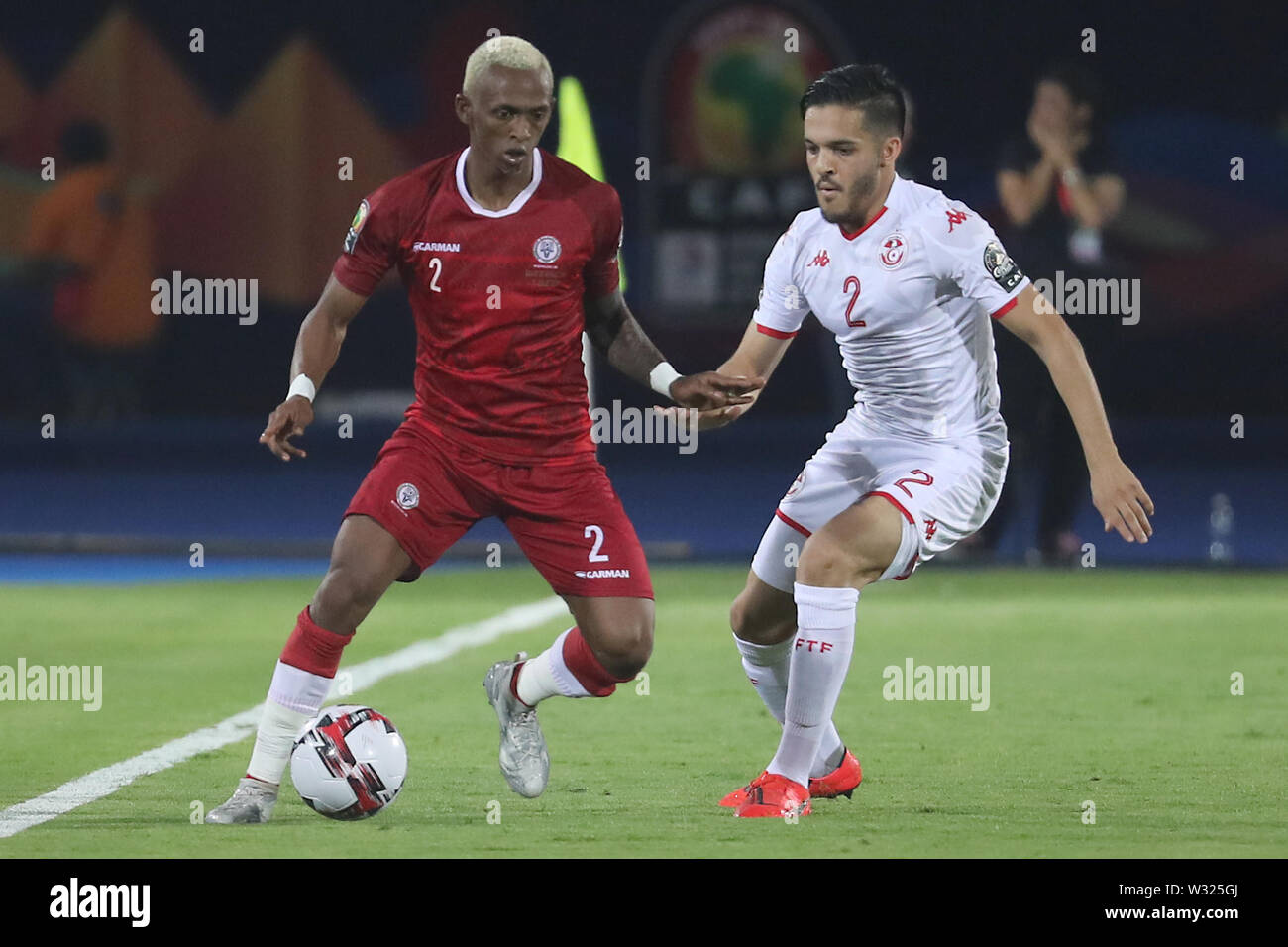 11 Juli 2019, Ägypten, Kairo: Madagaskars Carolus Andriamatsinoro (L) und der Tunesischen Wajdi Kechrida Kampf um den Ball während der 2019 Afrika Cup von Quartal Nationen letzte Fußballspiel zwischen Madagaskar und Tunesien Al-Salam Stadion. Foto: gehad Hamdy/dpa Stockfoto