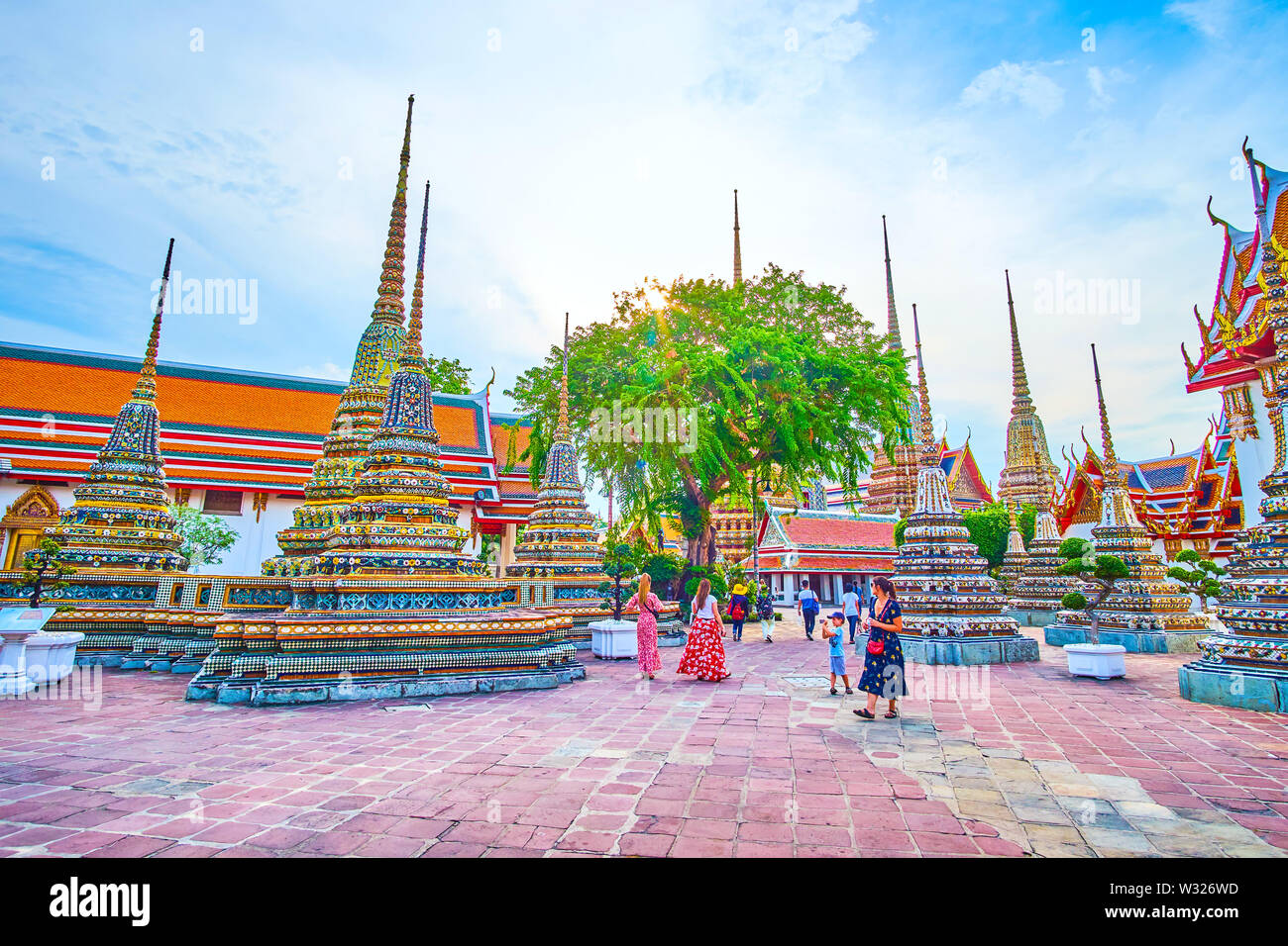 BANGKOK, THAILAND - 22. APRIL 2019: Die Touristen im Wat Pho Tempel mit Blick auf die prächtige Architektur der surriunding Schreine, am 22. April i Stockfoto