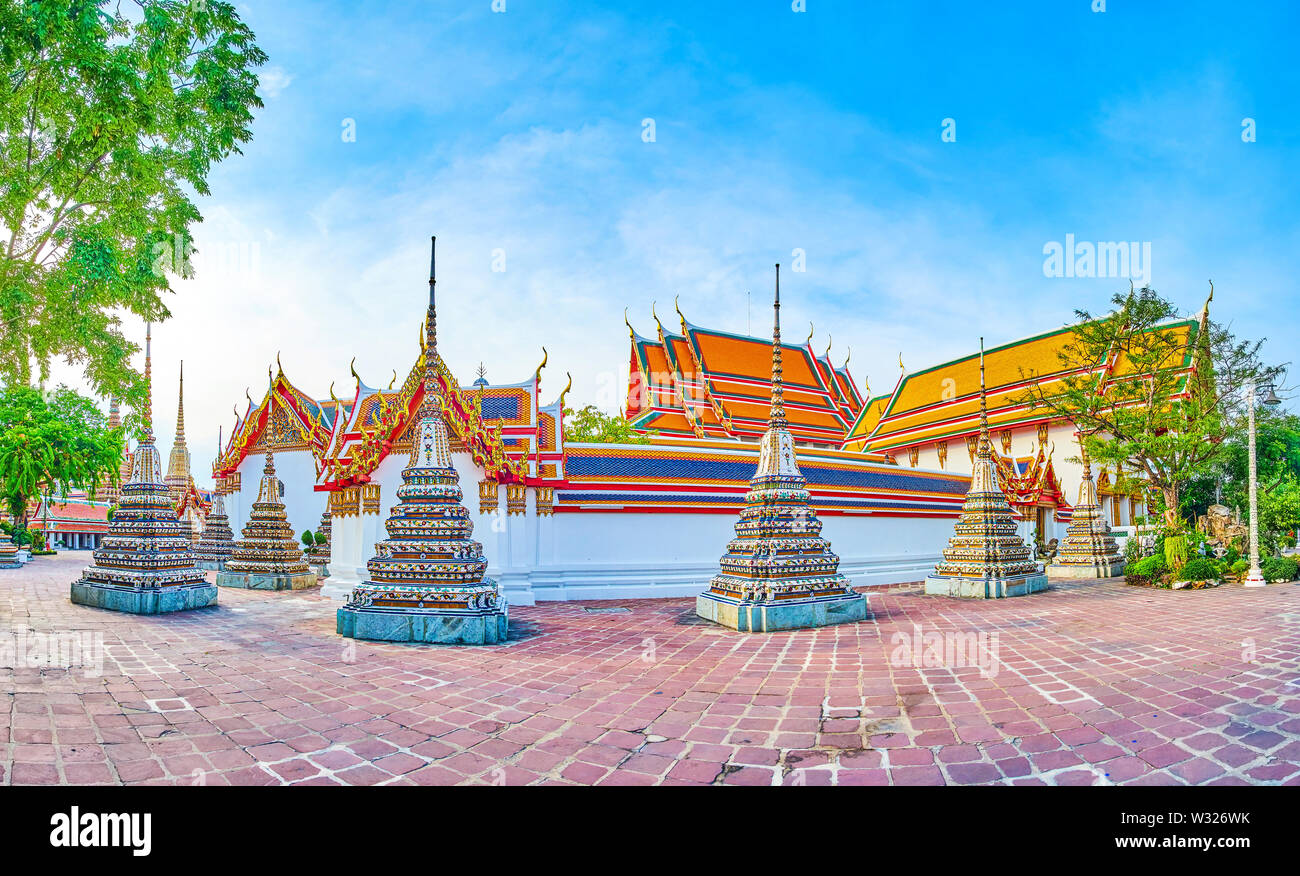 Panoramablick auf der Außenseite der Wände von Phra Rabiang Kreuzgang mit kleine Chedis, dass Prha Ubosot, dem wichtigsten Heiligtum der Wat Pho Tempel Komplex umgeben Stockfoto