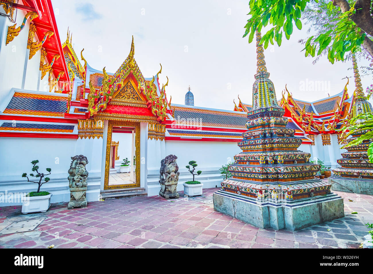 Der schöne Eingang zum Hof von Phra Rabiang Kreuzgang ist mit zwei chinesischen Stil foodogs mit verärgerten Maulkörbe, Wat Pho Tempel in Bangkok bewacht, Stockfoto