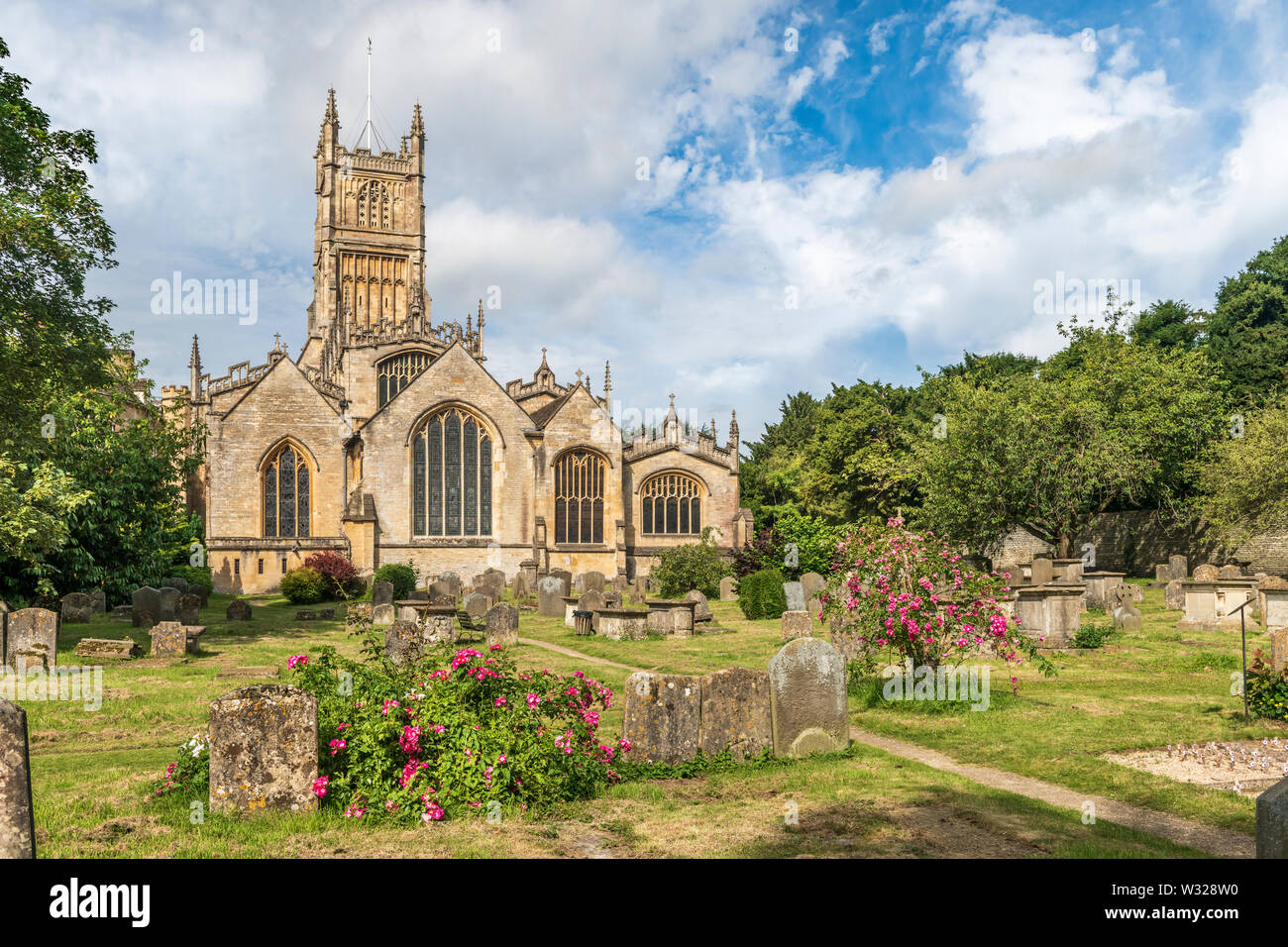 Der hl. Johannes der Täufer Kirche ist das Wahrzeichen Herzstück der Marktplatz in der wunderschönen Cotswold Stadt Cirencester in Gloucestershire. Stockfoto