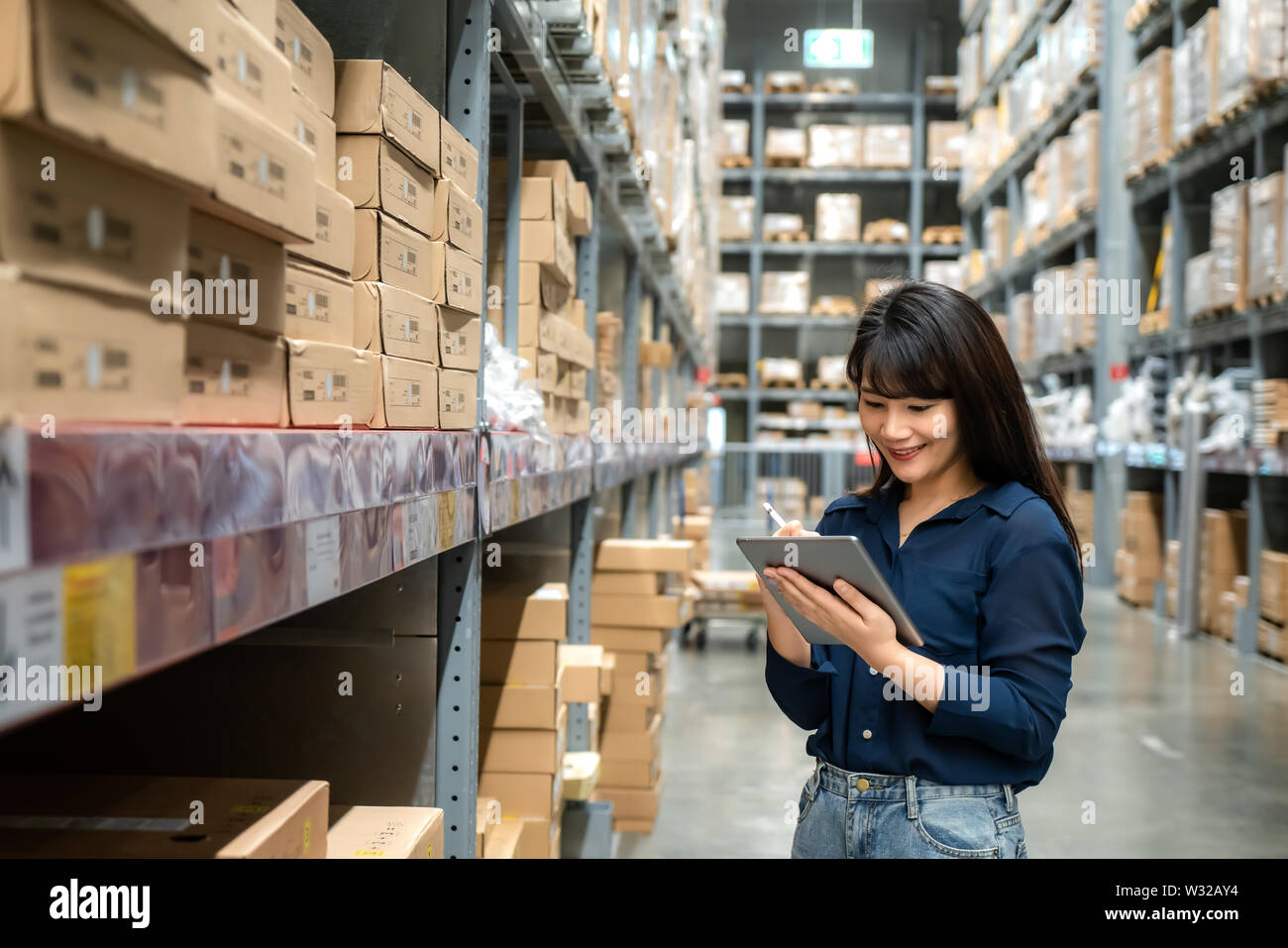Junge asiatische Frau Prüfer oder Trainee Personal Arbeit suchen und prüft die Anzahl der Elemente speichern von digitalen Tablet. Asiatische Eigentümer oder Small Business conce Stockfoto