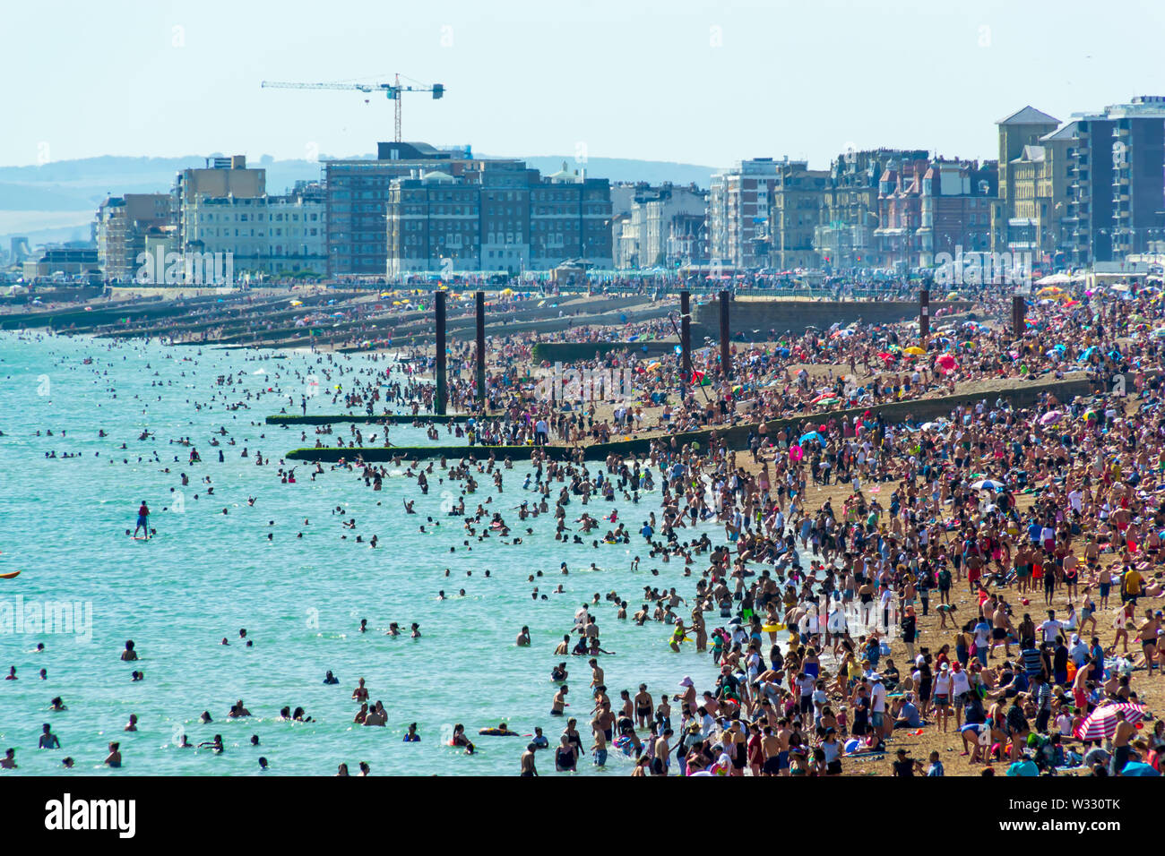 De Juni 29th, 2019 Strand von Brighton, Brighton und Hove, East Sussex, England. Tausende von Menschen auf der Sonnenterrasse entspannen. Stockfoto