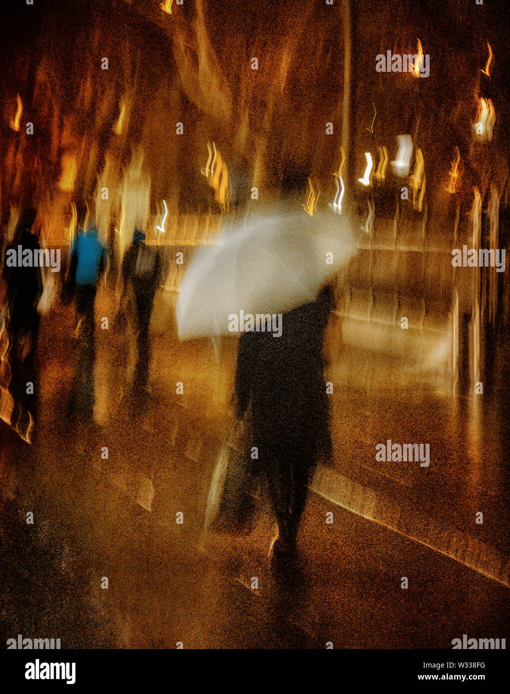 Frau geht mit einem Regenschirm in der Nacht in einem regen Sturm im Stadtzentrum Philadelphia Stockfoto