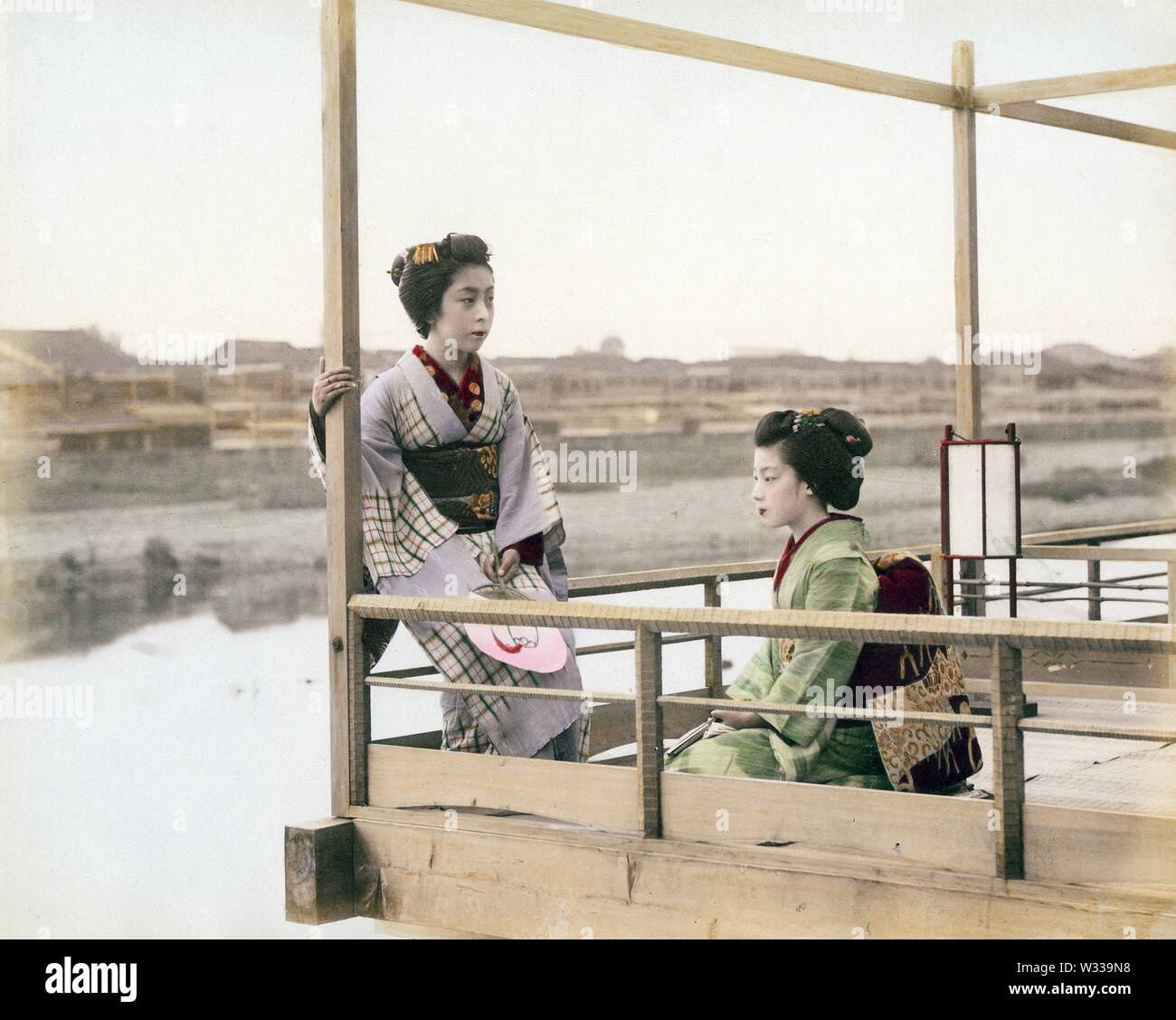 [1890s Japan - Zwei Geisha] - Zwei geisha Entspannen am noryo Yuka (Sommer) von einem Restaurant in Kyoto sind. Foto von Y. Isawa. 19 Vintage albumen Foto. Stockfoto