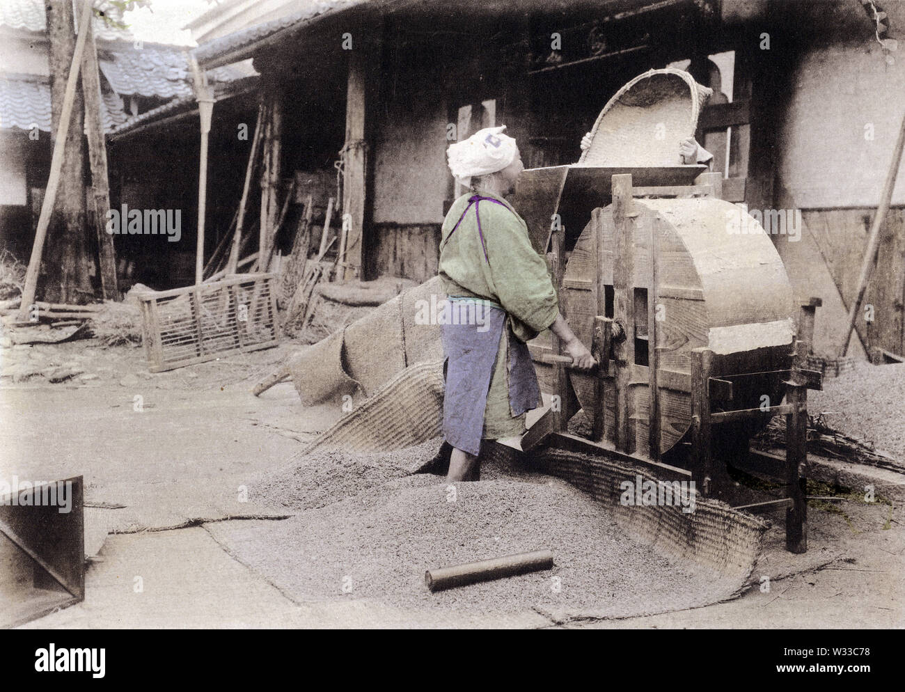 [1900s Japan - Japanische Bauern Worfeln Reis] - Anbau von Reis in Japan: Worfeln Reis mit einem toumi. Dieses Bild kommt von "den Reis in Japan", veröffentlicht im Jahr 1907 (Meiji 40) von Kobe Fotograf Teijiro Takagi. 11 von 19 20. Jahrhundert vintage Lichtdruck drucken. Stockfoto