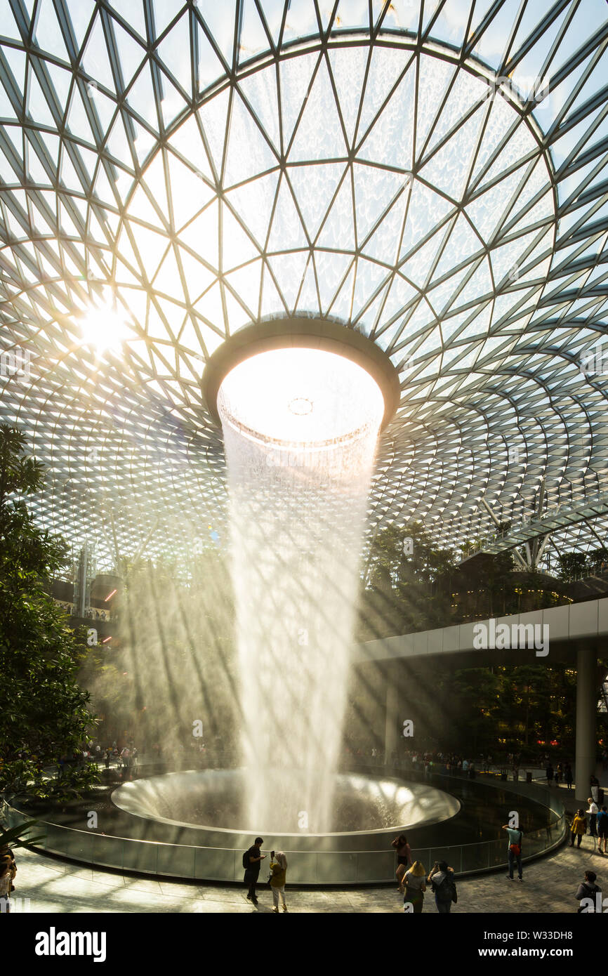 Vertikaler Blick auf den Wasserfall mit wunderschönem natürlichem Licht in den Jewel Changi Airport, Singapur. Stockfoto
