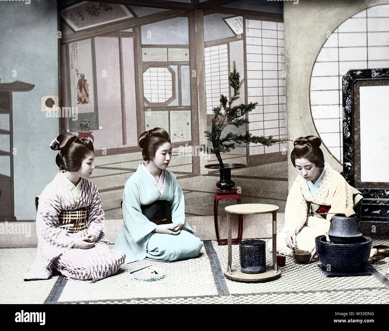[1890s Japan - Japanische Teezeremonie] - Frauen im Kimono und traditionelle Frisur genießen eine Teezeremonie. 19 Vintage Glas schieben. Stockfoto