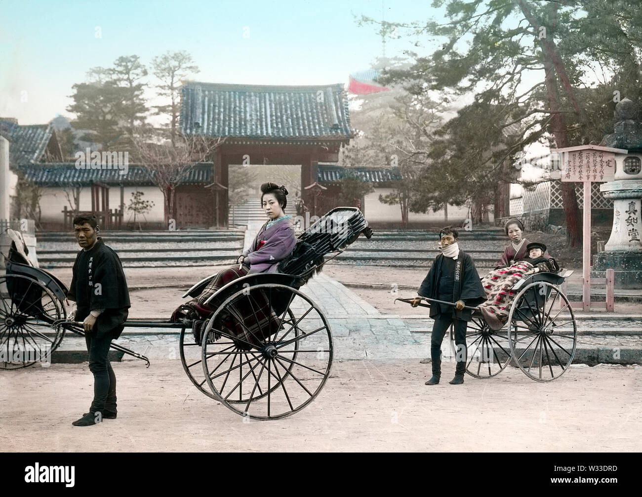 [1890s Japan - Japanische Frauen in der Rikscha] - eine Frau, Ihr Kind und die Magd in zwei rikschas am Vordereingang des Shinnyodo Tempel in Kyoto sitzen. Die rikscha Abzieher vor trägt ein happi Mantel. 19 Vintage Glas schieben. Stockfoto