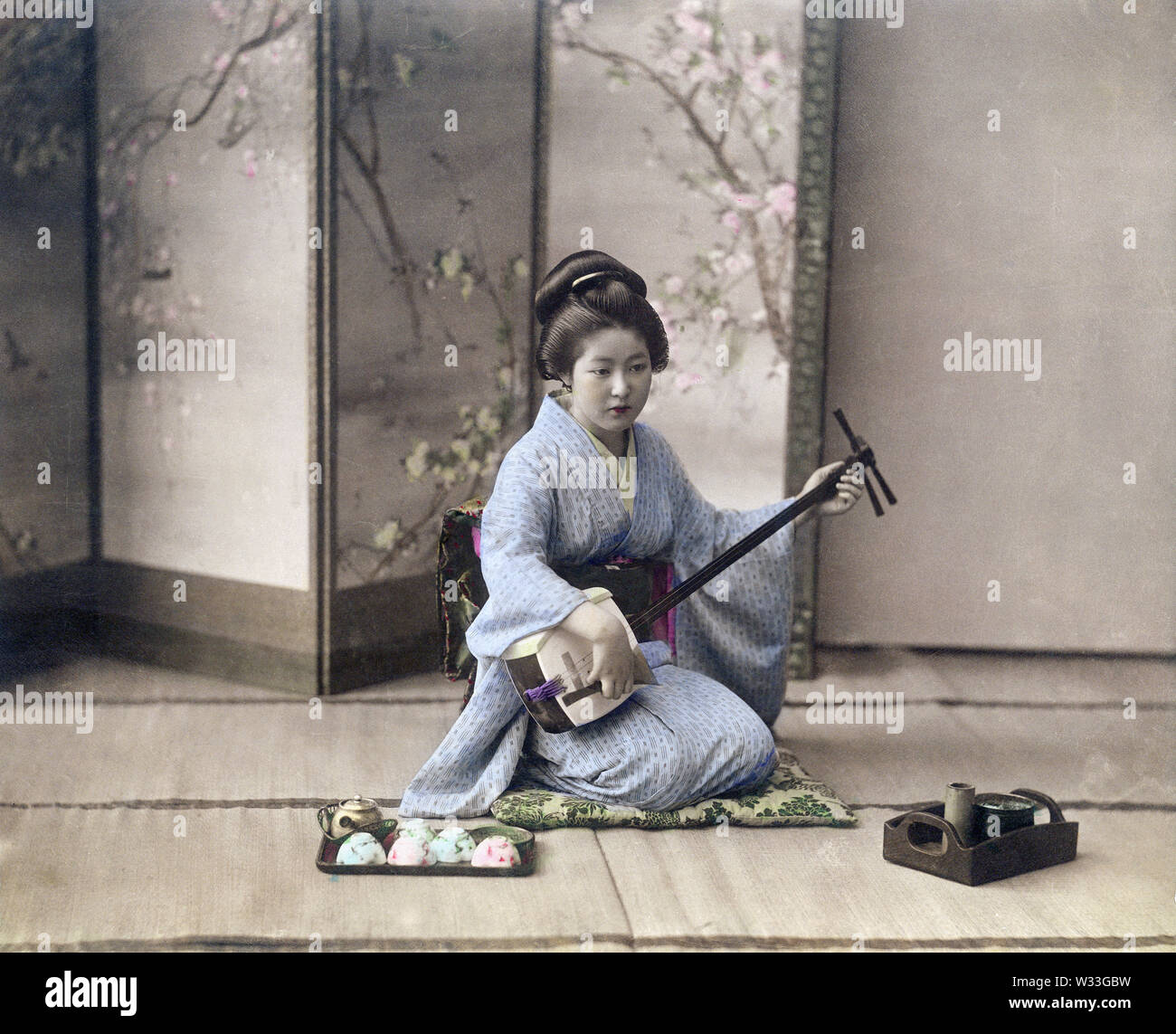 [1890s Japan - Geisha spielen die Shamisen] - eine Frau, die das Üben der Shamisen. 19 Vintage albumen Foto. Stockfoto
