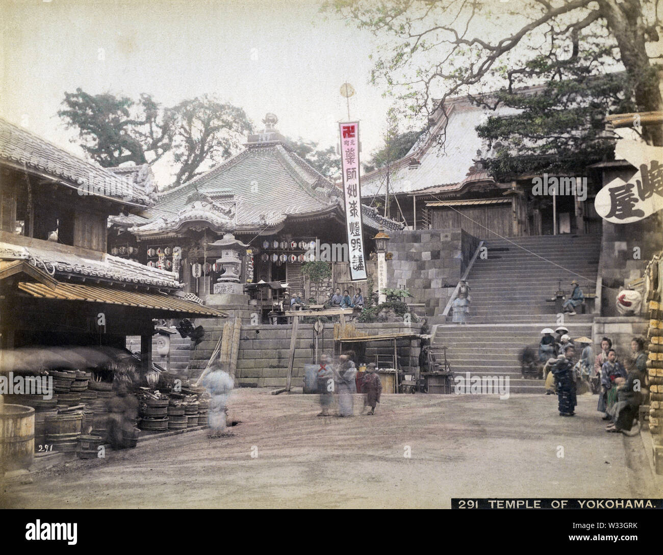 [1890s Japan - Zotokuin Tempel, Yokohama] - ein Shop vor Zotokuin, ein buddhistischer Tempel in Motomachi, Yokohama, Kanagawa Präfektur. Das Gebäude auf der linken Seite ist die Yakushi-tun. Es war der Horikawa Fluss, wo es auch heute noch befindet. Zotokuin wurde zerstört, von den großen Kanto-erdbeben von 1923 (taisho 12). 19 Vintage albumen Foto. Stockfoto