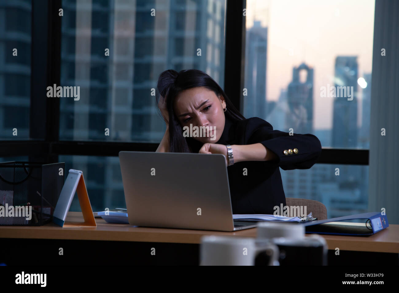 Business woman müde im Büro am Schreibtisch mit Computer und Überstunden Projekt am Arbeitsplatz sitzen Stockfoto