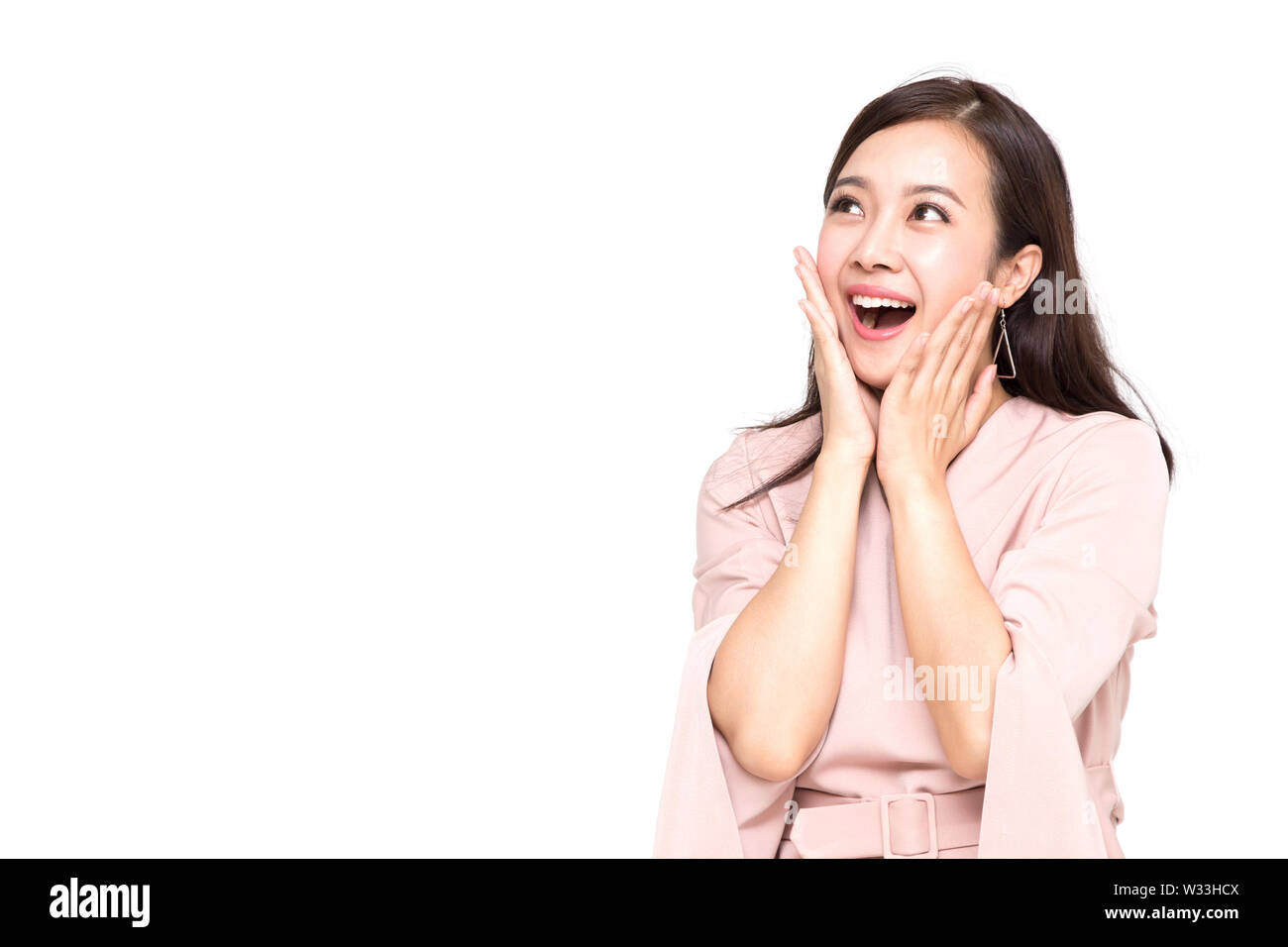 Portrait von aufgeregt schreienden jungen asiatischen Frau im rosa Kleid mit weißem Hintergrund, Wow und überrascht Konzept Stockfoto