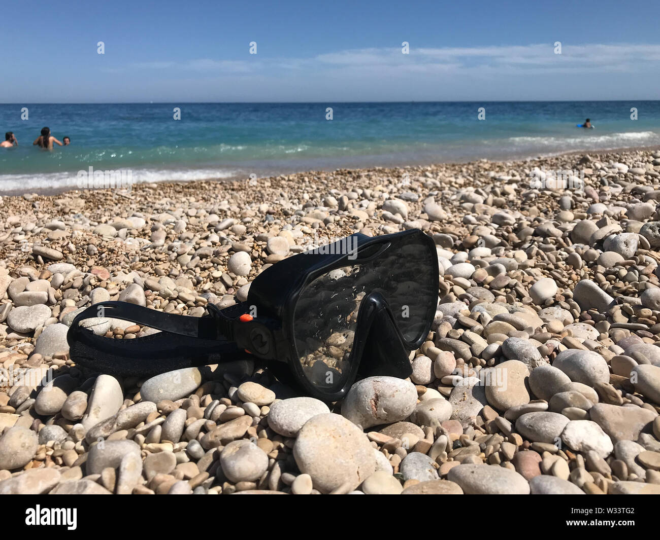 Nahaufnahme einer Taucherbrille auf die Steine von einem Strand. Stockfoto