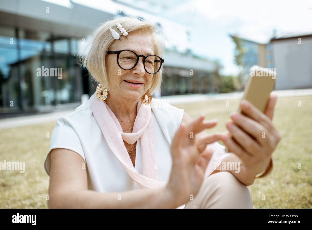 Schöne und elegante ältere Frau mit Smartphone im Freien in der Stadt. Konzept eines aktiven Geschäftsleben auf Ruhestand Stockfoto