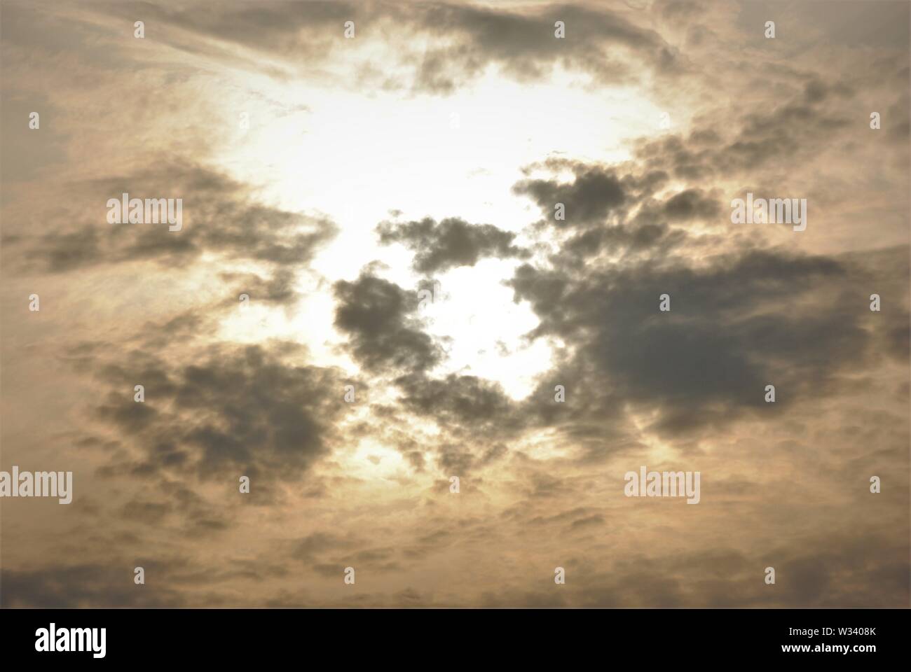 Hazy diffuse Sonne hinter grauen Wolken in einem Fuzzy abstrakten Himmel Stockfoto