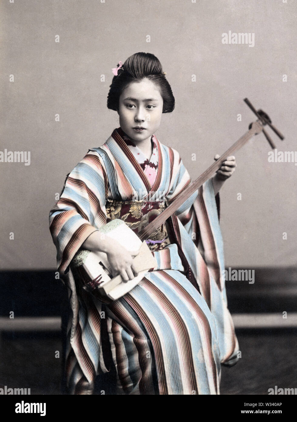 [1890s Japan - Japanische Frau üben die Shamisen] - Frau im Kimono und traditionelle Frisur Üben der Shamisen. 19 Vintage albumen Foto. Stockfoto