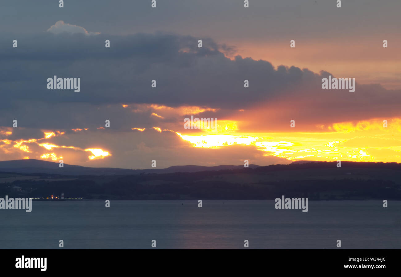 Eine schöne Landschaft Bild von einem Sonnenuntergang über dem Firth von weiter in der Nähe von Edinburgh in Schottland, Vereinigtes Königreich Stockfoto