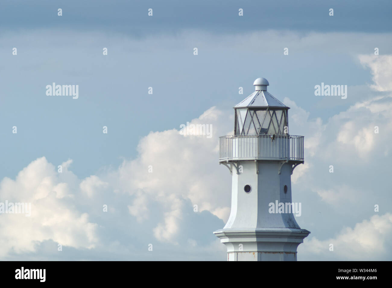 Der obere Rand der weißen Leuchtturm gegen eine weiße Wolke Hintergrund Stockfoto
