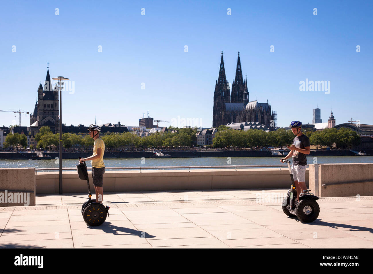 Segway Treiber direkt am Rhein im Stadtteil Deutz, Blick zum Dom, Köln, Deutschland. Segway Fahrer bin Rheinboulevard in DEut Stockfoto