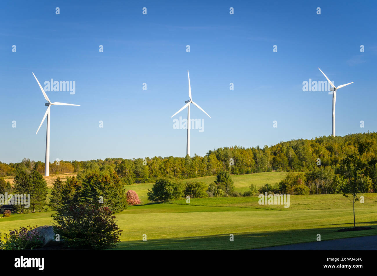 Windenergieanlagen in einer Landschaft und blauer Himmel. Erneuerbare Energien. Stockfoto